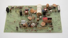 Circuit board with gold connector pins and a bulky capacitor